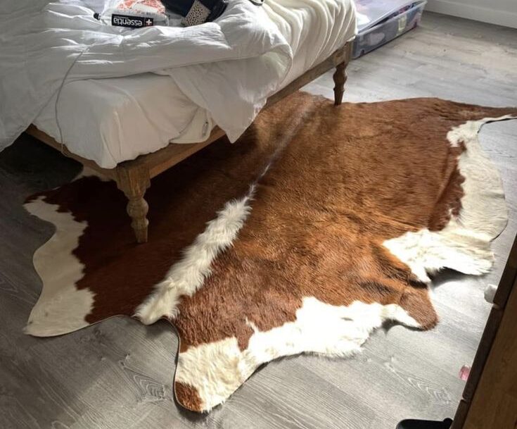 Classic brown and white cowhide rug in classic bedroom