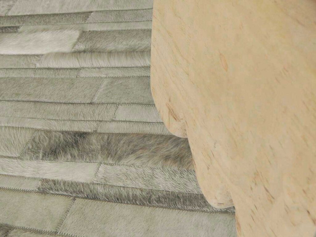 White and gray patchwork cowhide rug and stool detail
