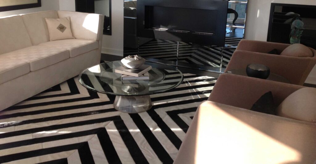 Living room with custom patchwork cowhide rug in black and white stripes