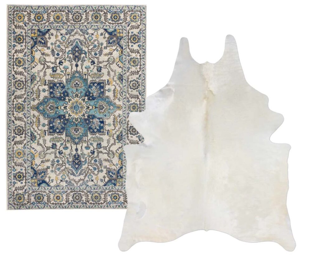 Blue toned persian rug layered with a white cowhide rug