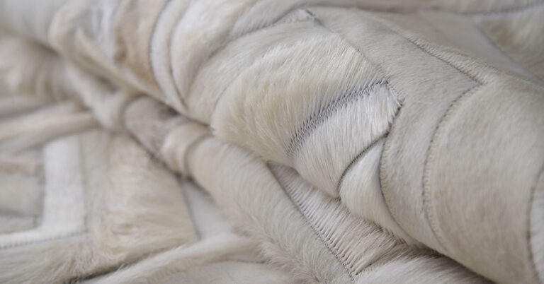 Detail of a creamy white Toto patchwork cowhide rug