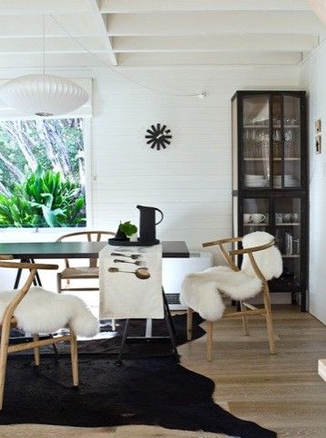 Black hide combined with a light wooden floor, white walls and lamp. The crisp sheepskins give this space the exact and perfect balance.
