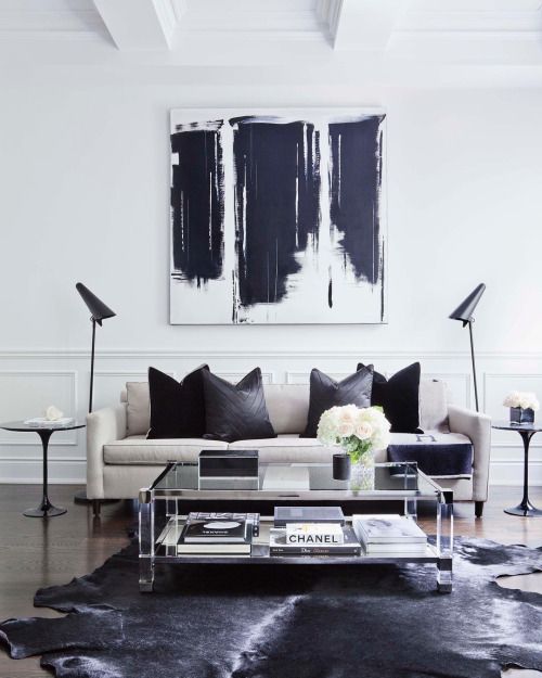 Black cowhide rug in a contemporary super light living room with black details.