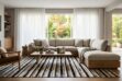Sophisticated Scandinavian living room featuring a large beige, black, and white striped patchwork cowhide rug under a heavy cotton sectional sofa with a wooden base, illuminated by natural light from open windows.
