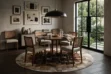 A modern dining room scene featuring a round Round Beige and Brown Squares Cowhide Rug placed under a walnut dining table with five cane-back chairs. The patchwork rug, showing its multi-toned square pattern, is the central element on the dark wood floor.