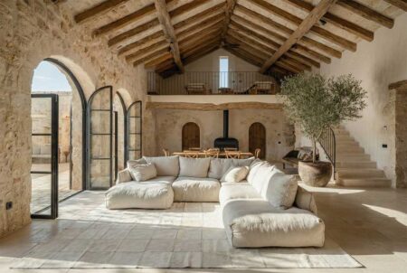 white-squares-patchwork-cowhide-rug-in-french-mallorcan-living-room White squares patchwork cowhide rug in Mediterranean living room with stone walls and neutral sofa