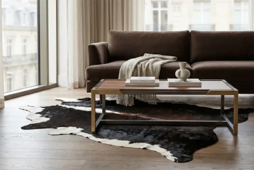 luxurious set-up of a taupe velvet sofa and a fine wooden table with metallic details, and a unique mahogany brown cowhide rug