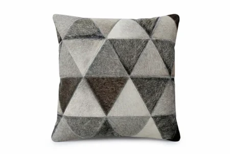 Kata cowhide pillow in gray and taupe A detailed, frontal photograph of a single square Kata pillow cover made entirely of cowhide patchwork. The front features a precise geometric pattern of hair-on-hide triangles in varying natural shades of light grey, medium grey, and dark taupe, arranged in an alternating, tiled pattern. The individual patches are connected with visible, even grey stitching, and the natural texture of the hair-on-hide is prominent. The cushion is shown against a neutral, plain background.