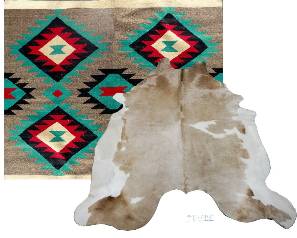 Navajo / Kilim area rug topped with a shiny cowhide rug