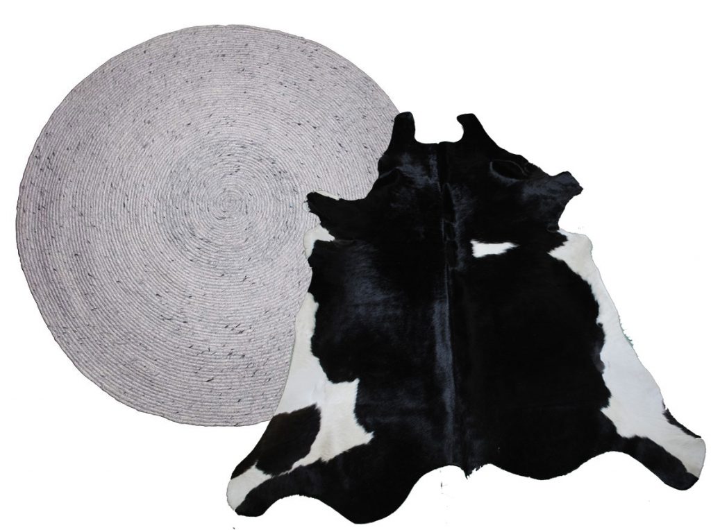 Round wooven rug matched with a black and white cowhide rug