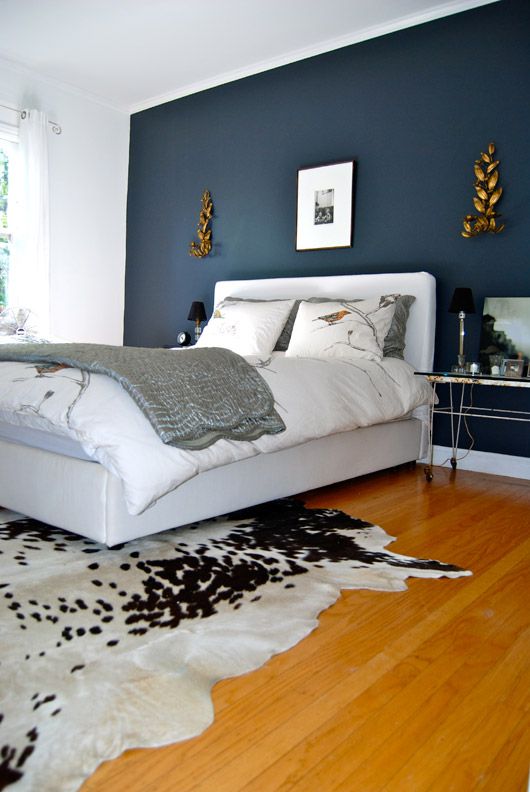 Black and white cowhide area rug in a bright bedroom