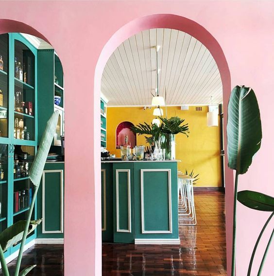 Pink walls, arches, green bar and a pop of yellow
