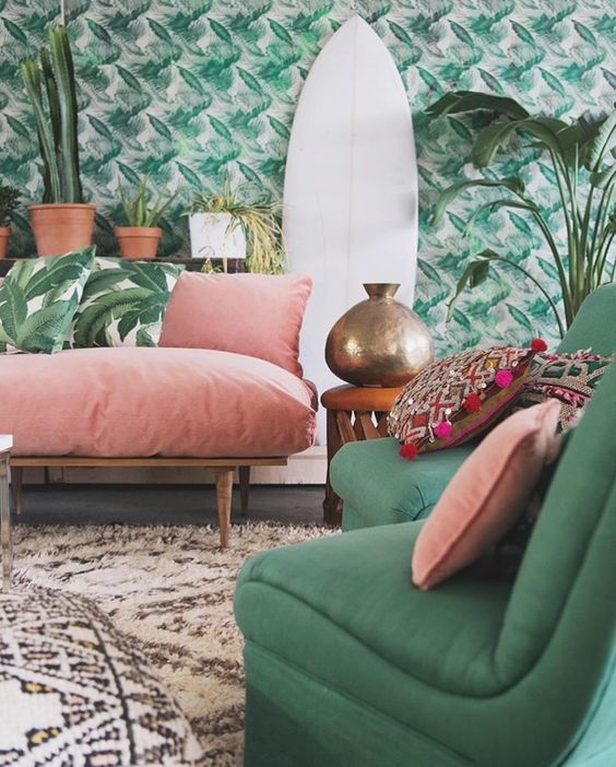 Emerald and pink soft sofas and leaves wallpaper