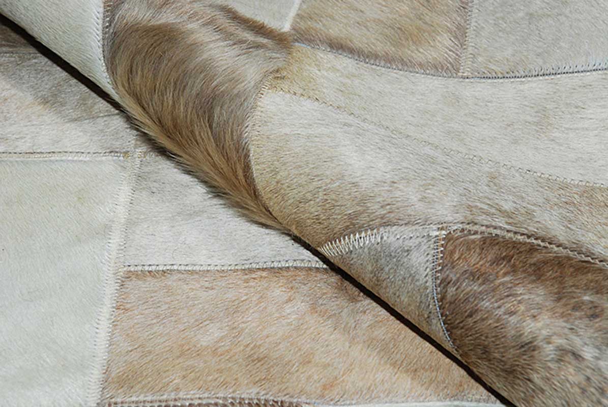 Detail of a beige patchwork cowhide rug by Shine Rugs