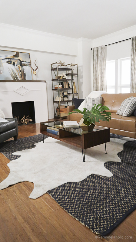 Angled white cowhide rug over a large area rug