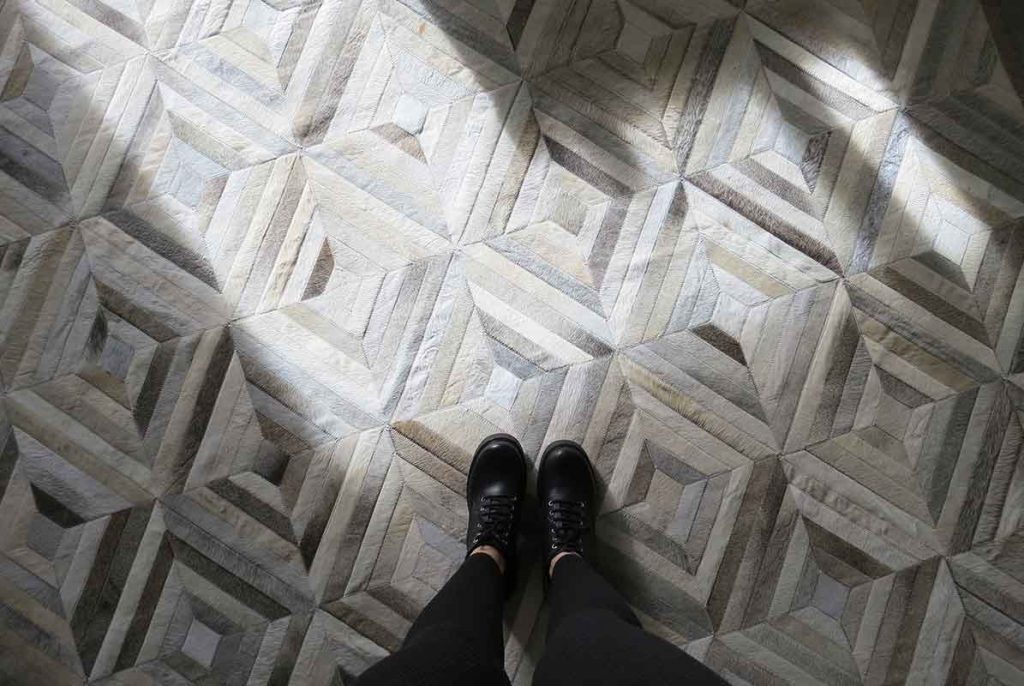 Taupe and cream patchwork cowhide rug in diamond pattern