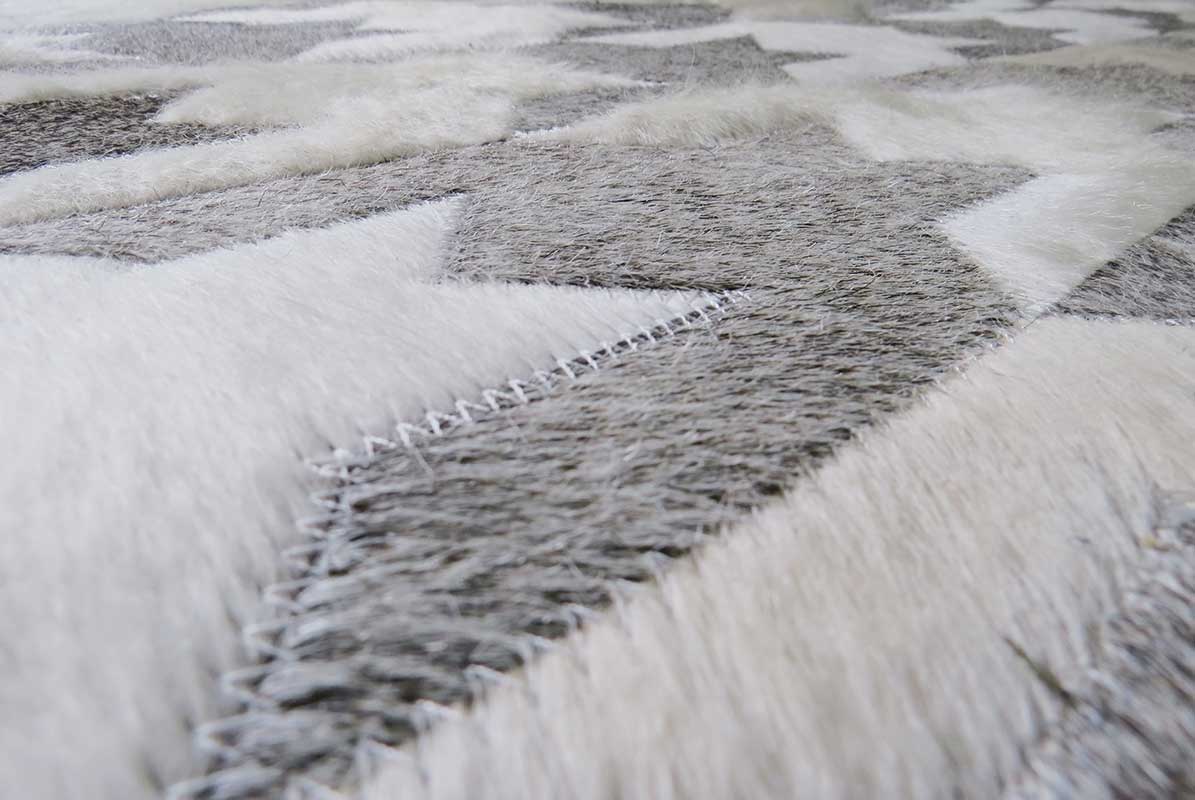 Close up of a Taupe and Cream Houndstooth Patchwork Cowhide Rug