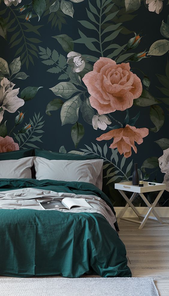 dark floral wallpaper in a bedroom. Tones of emerald green and pink hues with green bedding