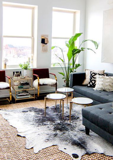 Salt and pepper black and white cowhide area rug in a bright living room