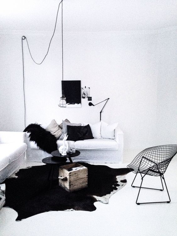 Black and white cowhide area rug in a minimal space