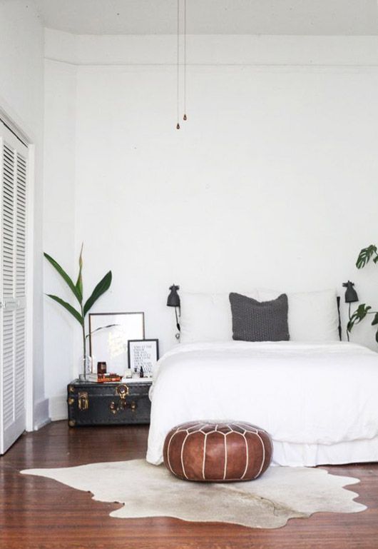 Cowhide rug in a tall ceiling, white, modern bedroom