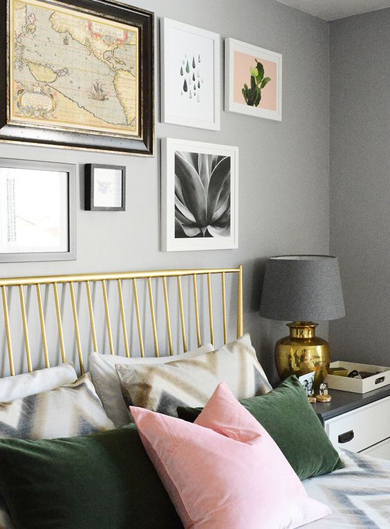 Wall art, brass bed and pink + green cushions