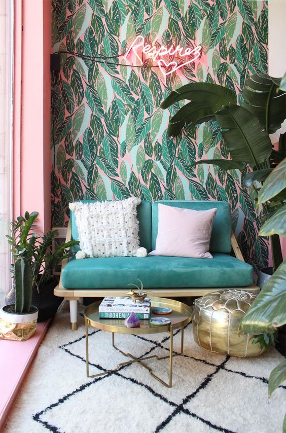 Green and pink leaves wallpaper, neon sign and emerald sofa