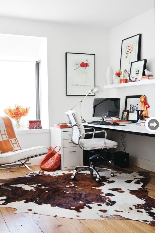 White walls and furniture with warm brown and white cowhide area rug