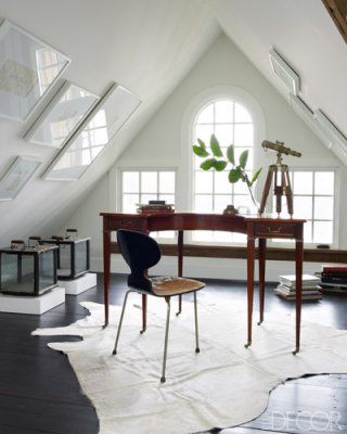 Home office with dark floor, white walls and a huge albino white cowhide rug