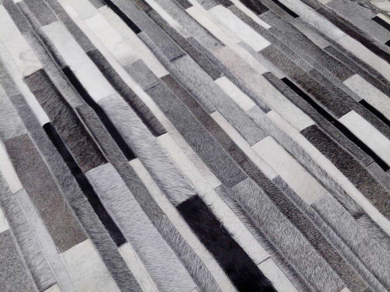 Custom striped patchwork cowhide rug for Jonathan. He wanted a full range, from white to black and everything in between