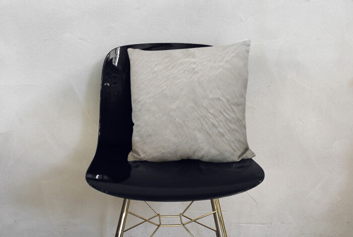 Unique Cream White Cowhide Throw Pillow on Modern Black Chair