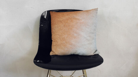 Gradient Soft Beige Pillow on a fancy black chair