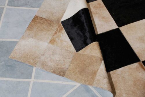 detail of a beige and black cowhide patchwork rug in Squares