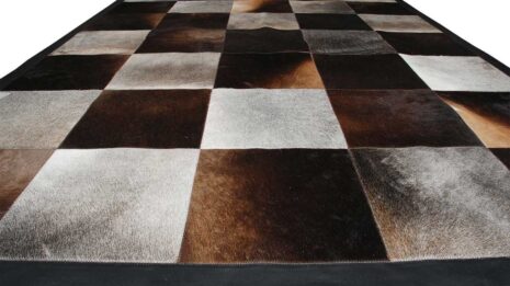 Gray and chocolate brown cowhide patchwork rug in squares with a leather border