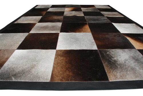 Gray and chocolate brown cowhide patchwork rug in squares with a leather border