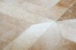 Hair detail of a beige patchwork cowhide rug in the cube design