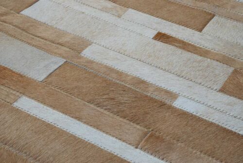 Hair on hide detail of Beige and white patchwork cowhide rug designed in stripes