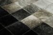 Hair on hide detail of white, gray and black leather area rug in squares