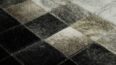 Hair on hide detail of white, gray and black leather area rug in squares