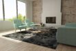 Brown and Black Patchwork Cowhide in Rug in a bright living room with aqua sofas