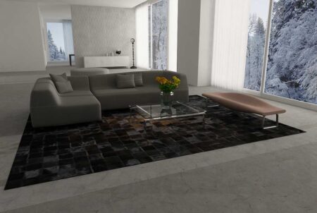 Big brown and Black Patchwork Cowhide Rug under a gray cough in a big living room Big brown and Black Patchwork Cowhide Rug under a gray cough in a big living room