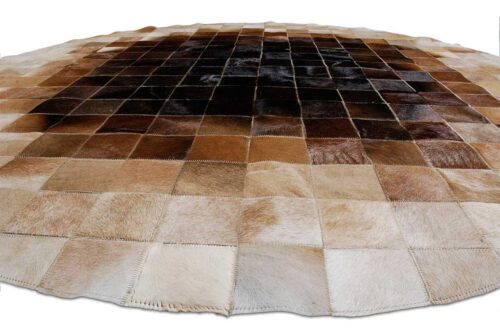 Low view of a Round Beige and Brown gradient patchwork cowhide rug