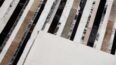 Detail of a black, beige and black with salt and pepper cowhide patchwork rug designed in stripes