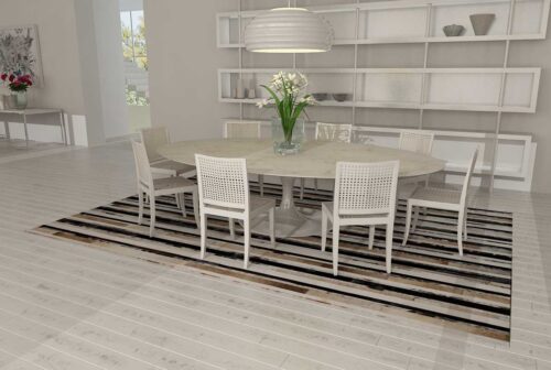 Stripes beige and black and white patchwork cowhide rug with a Tulip table in a minimal dining room