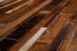 Detail of a toasted brown patchwork cowhide rug in stripes