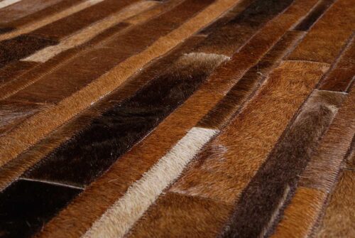 Detail of a toasted brown patchwork cowhide rug in stripes
