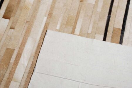 Detail of a Beige and chocolate Patchwork Cowhide Rug Designed in stripes with backing Detail of a Beige and chocolate Patchwork Cowhide Rug Designed in stripes with backing