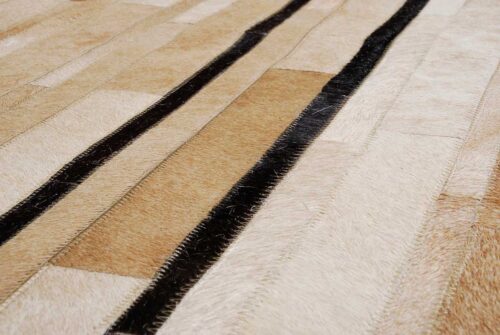 Detail of a Beige and chocolate Patchwork Cowhide Rug Designed in stripes