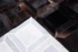 Detail of a Cube Patchwork Cowhide Rug in chocolate brown with backing