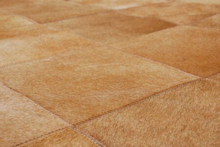 Close-up of a Dark Beige Patchwork Cowhide Rug in 8 inches Squares Close-up of a Dark Beige Patchwork Cowhide Rug in 8 inches Squares